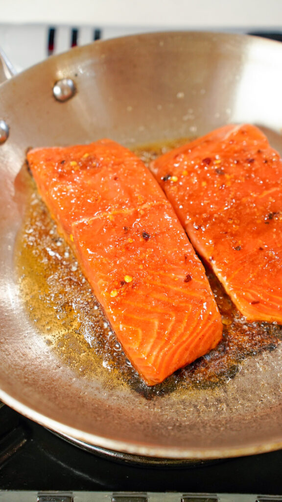 Hot Honey Sriracha Asian Marinade for Salmon in a skillet with the fish.