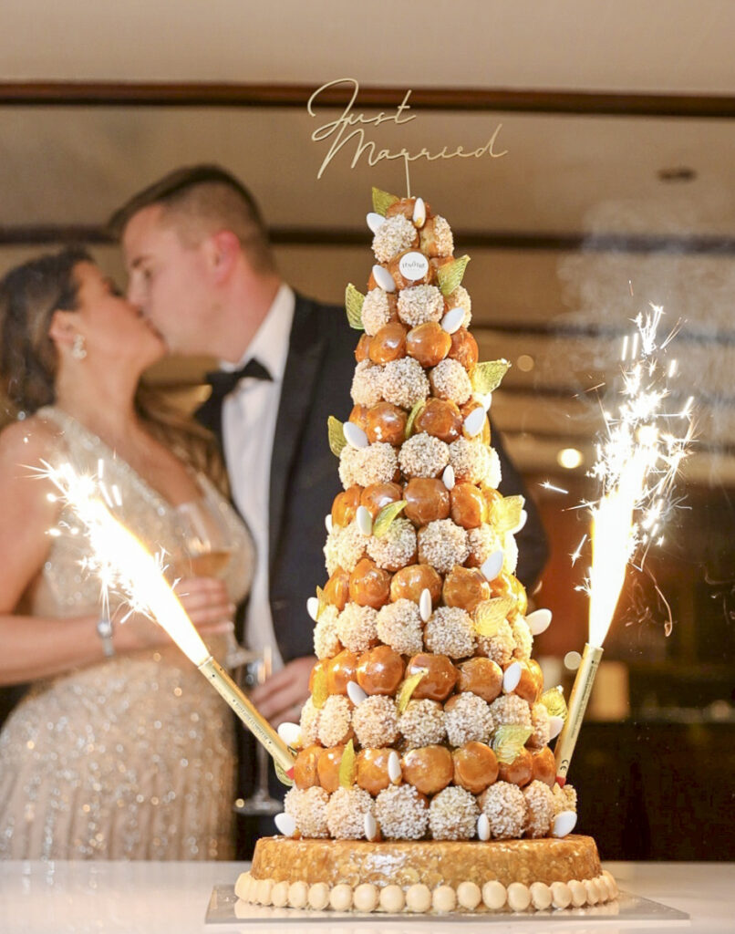 Couple at a destination wedding with a wedding cake croquembouche