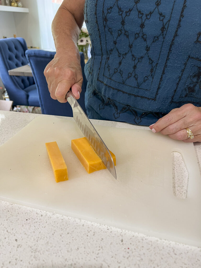 Woman slicing cheese for a grazing table