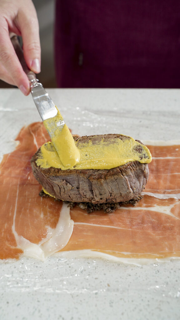 Dijon mustard on a filet for beef wellington.