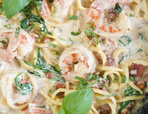 Tuscan Seafood Pasta with White Sauce garnished with fresh basil.
