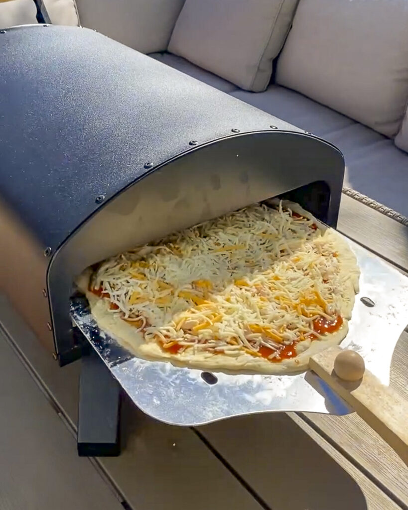 Pizza going into a Bertello Pizza Oven.