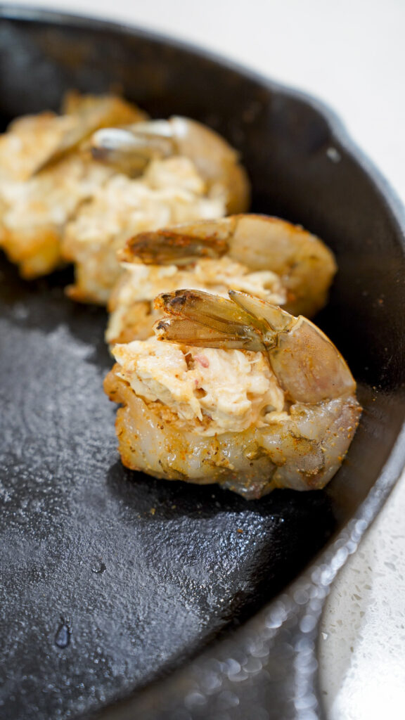 Crabmeat stuffed shrimp in a cast iron pan.
