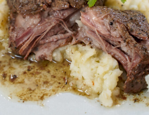 Plate of sous vide beef short ribs on mashed potatoes.