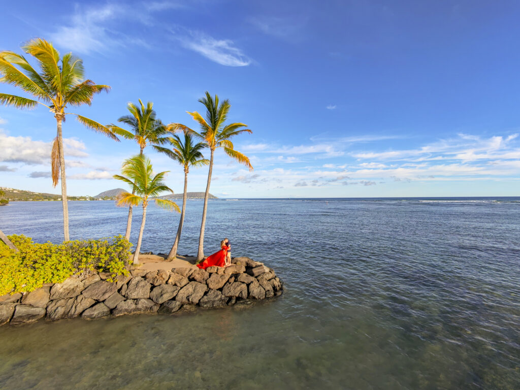 Couple hugging on the shore of the Kahala resort.