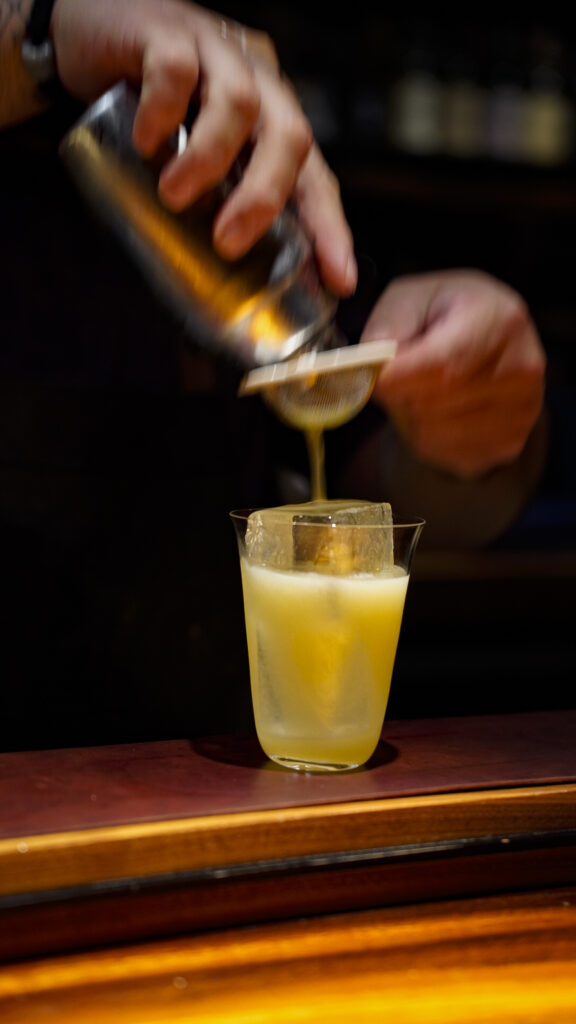 A bartender making a Tiki drink at bar leather apron, a romantic thing to do in Oahu, Hawaii.