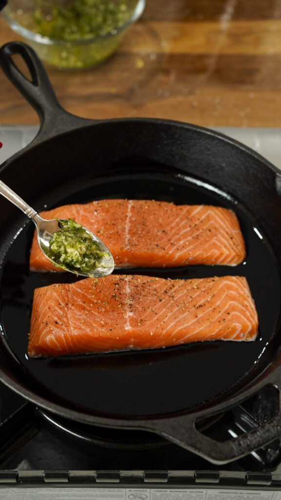 Baked Mediterranean salmon recipe being topped with a gremolata.