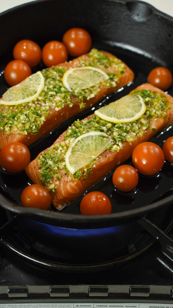 A tasty baked Mediterranean salmon recipe in a cast iron skillet.