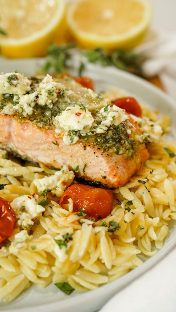 Baked Mediterranean Salmon Recipe with Marinated Feta on a platter with orzo.
