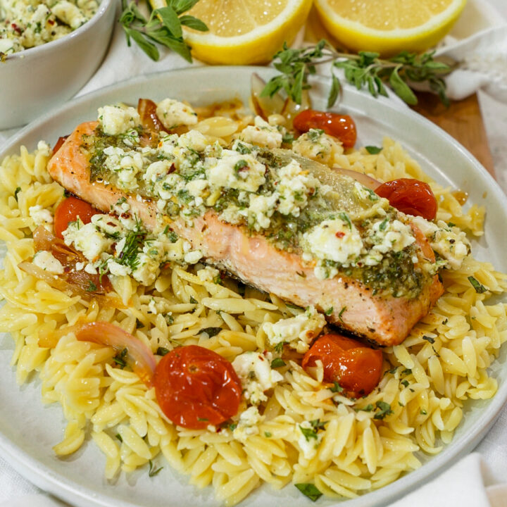 Baked Mediterranean Salmon Recipe with Marinated Feta on a platter with orzo.