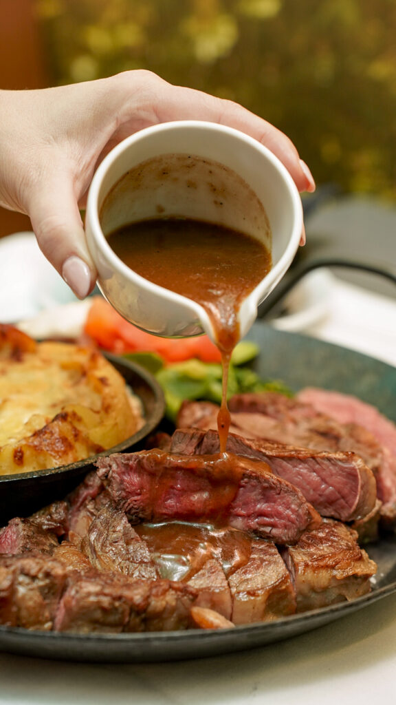 Sauce being poured on sliced steak in Nuremberg, Germany.