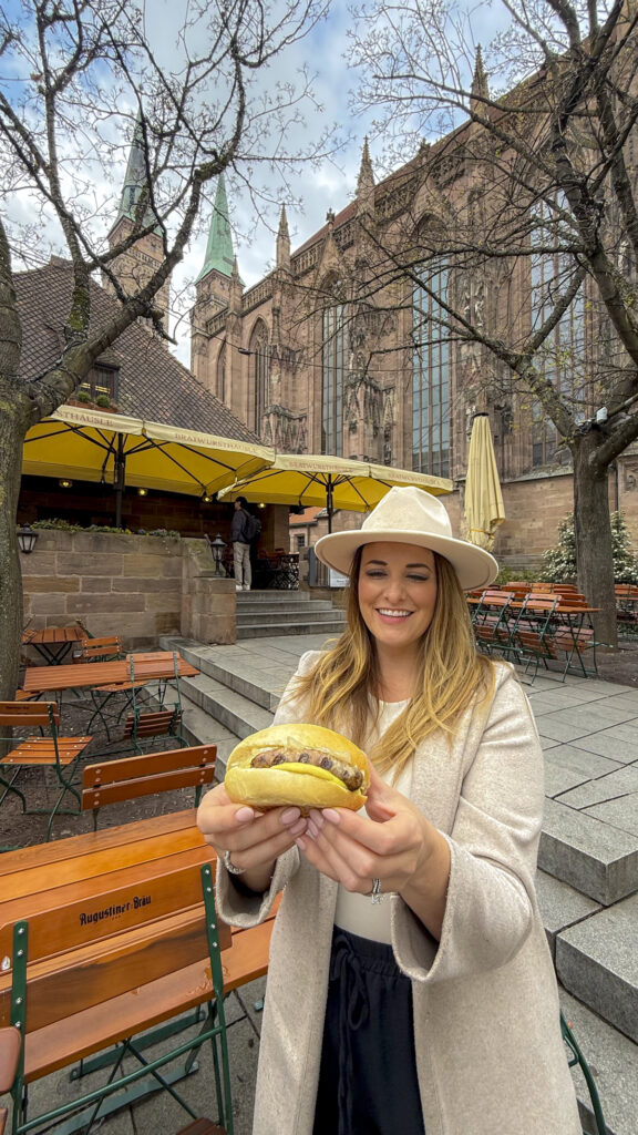 Woman holding a brat in a bun in Nuremberg, Germany.