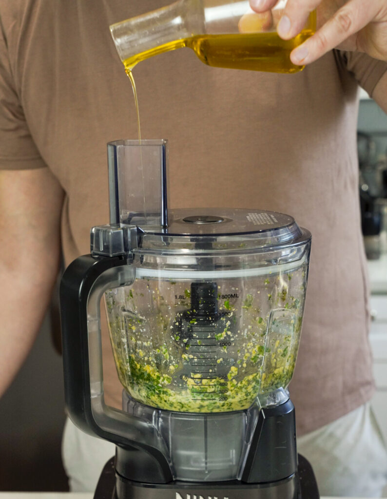 Man making homemade pesto for a grilled pesto salmon recipe.