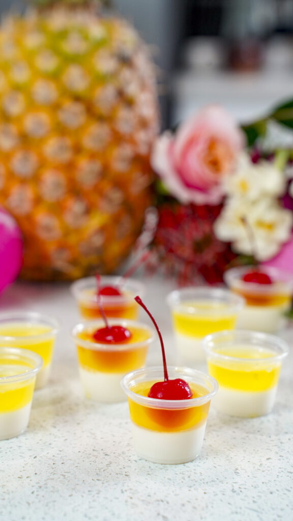Pina Colada Jello Shots Recipe topped with a cherry.