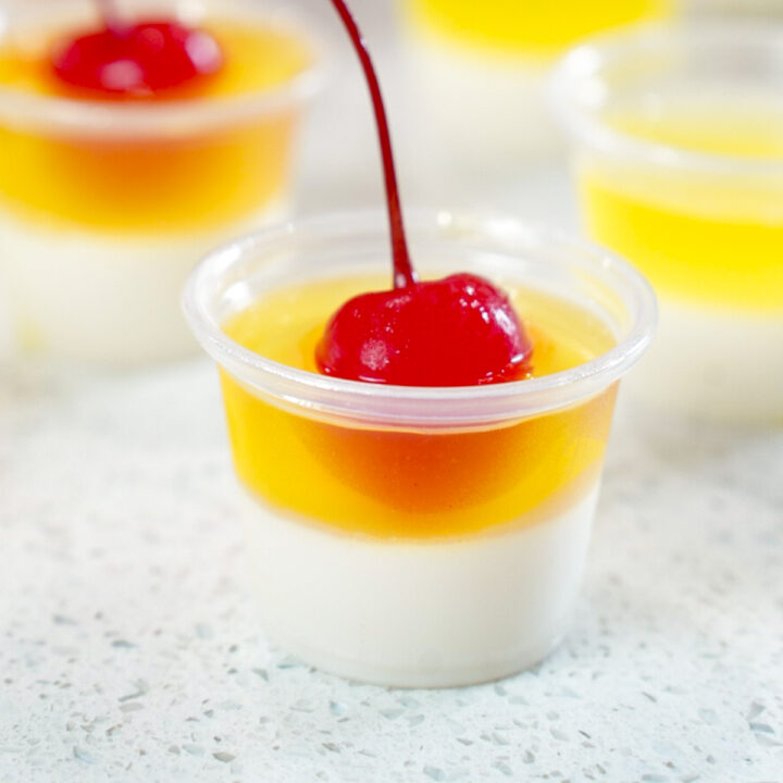 A Pina Colada Jello Shots Recipe topped with a cherry.