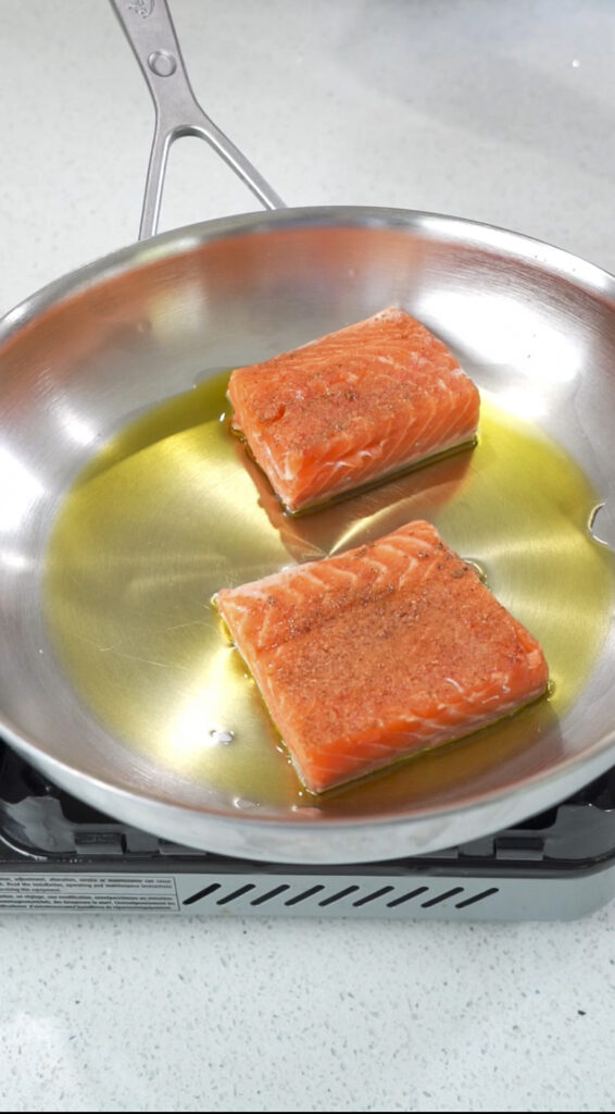 Salmon in a pan for a seared salmon eggs benedict recipe.