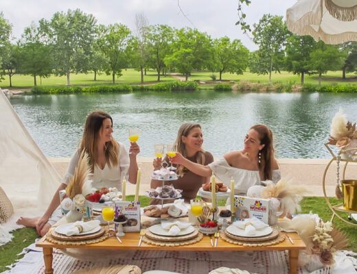 Women with platters of wonderbread sweets at a luxury picnic.