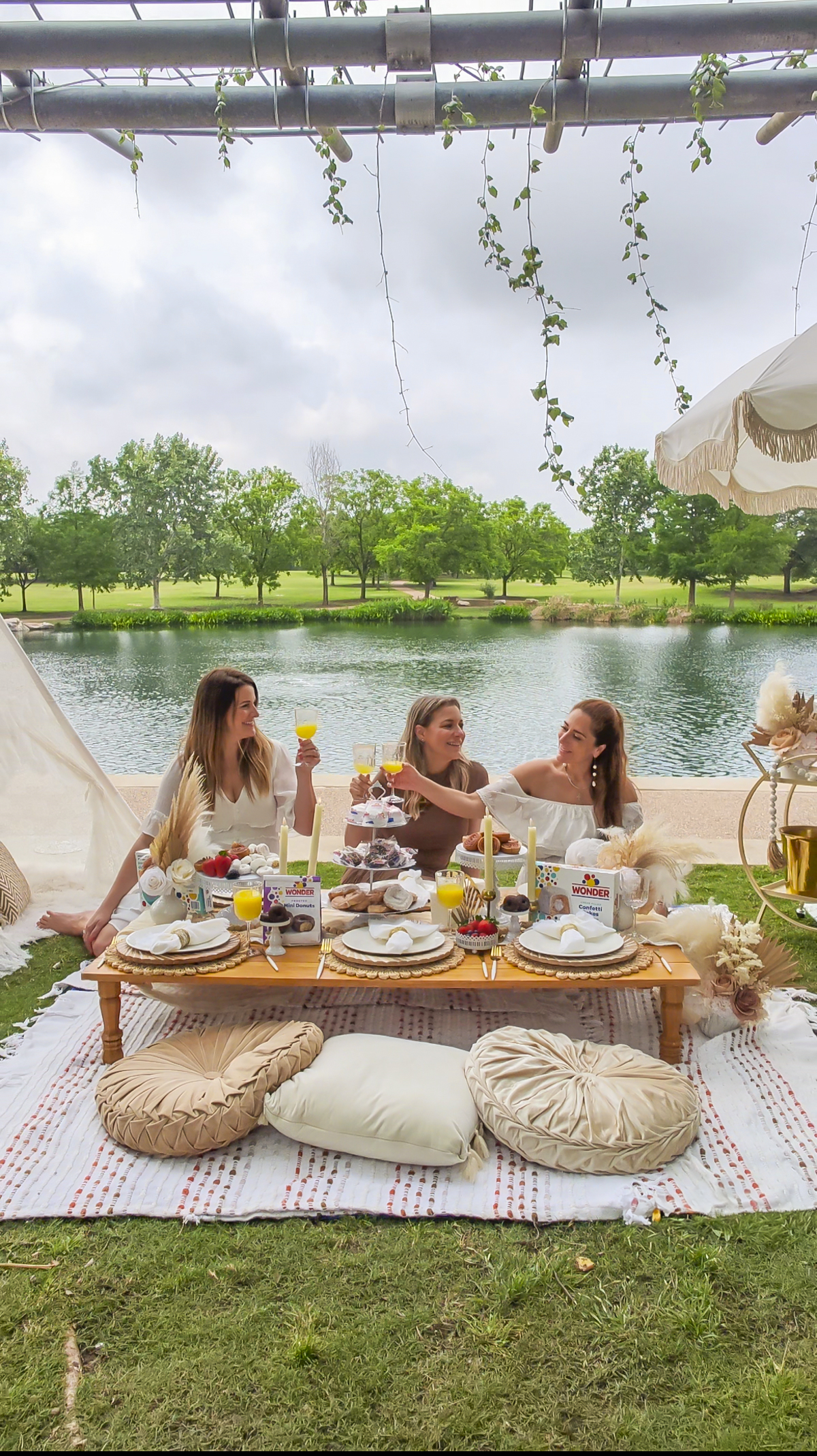 Women with platters of wonderbread sweets at a luxury picnic.