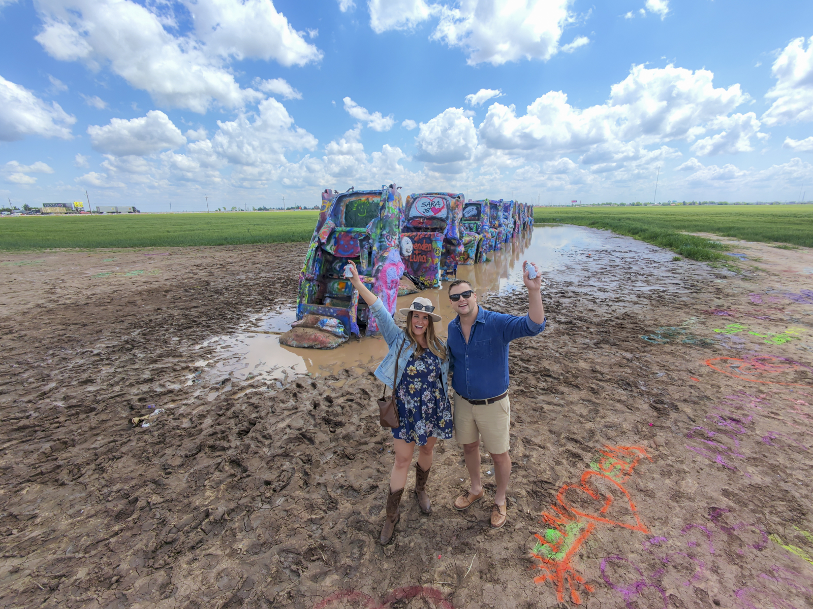 Couple with spray paint aat Cadillac Ranch - one of the most unique things to do in Amarillo, Texas.