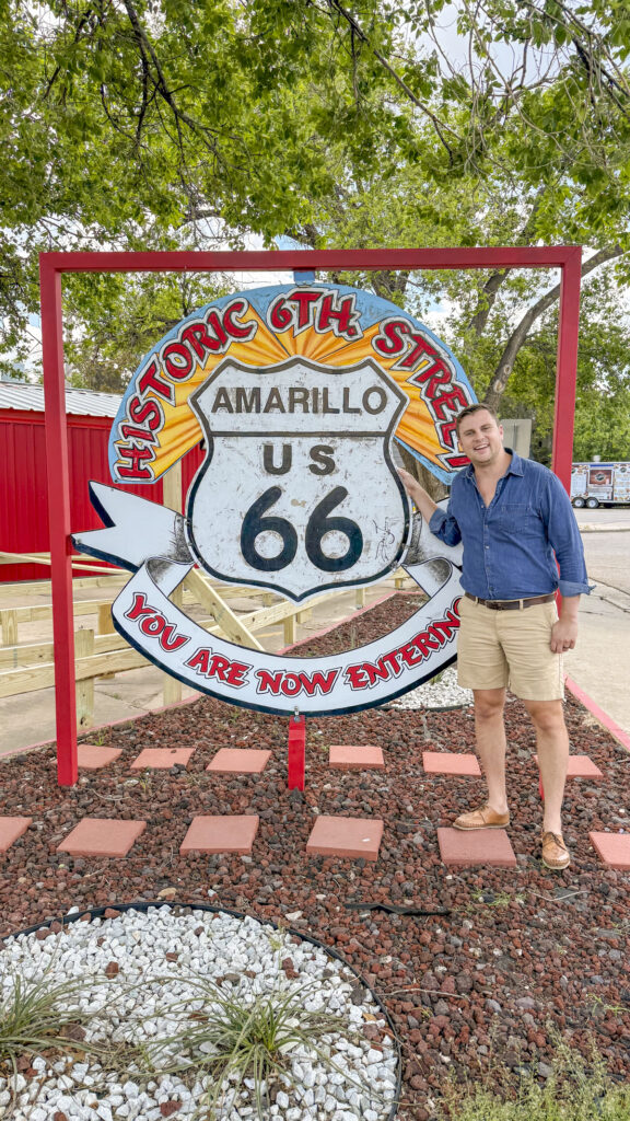 Man standing next to Route 66 sign in Amarillo, Texas.