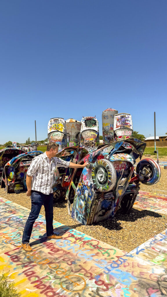 Man with spray paint at Cadillac Ranch - one of the most unique things to do in Amarillo, Texas.