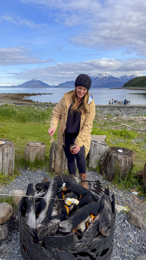 Woman roasting smores at Orca Point Lodge on a whale watching tour, one of the top things to do in Juneau, Alaska.