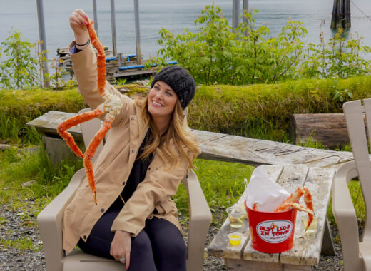 Woman holding a crab leg from Tracy's Crab Shack in Juneau, Alaska.