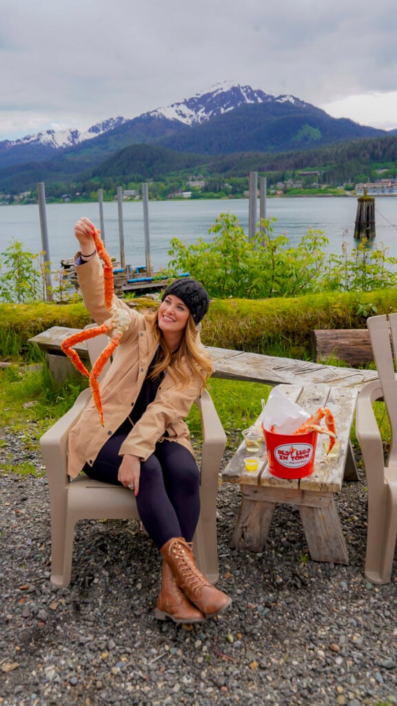 Woman holding a crab leg from Tracy's Crab Shack in Juneau, Alaska.