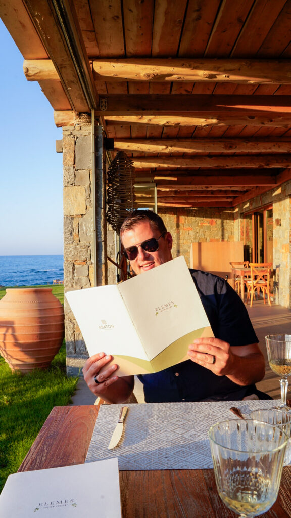 Man with a menu at Elemes restaurant in Crete.