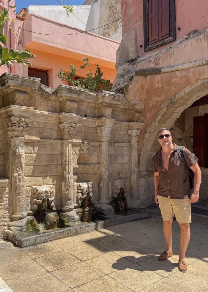Man standing by a fountain in Rethymno Crete.