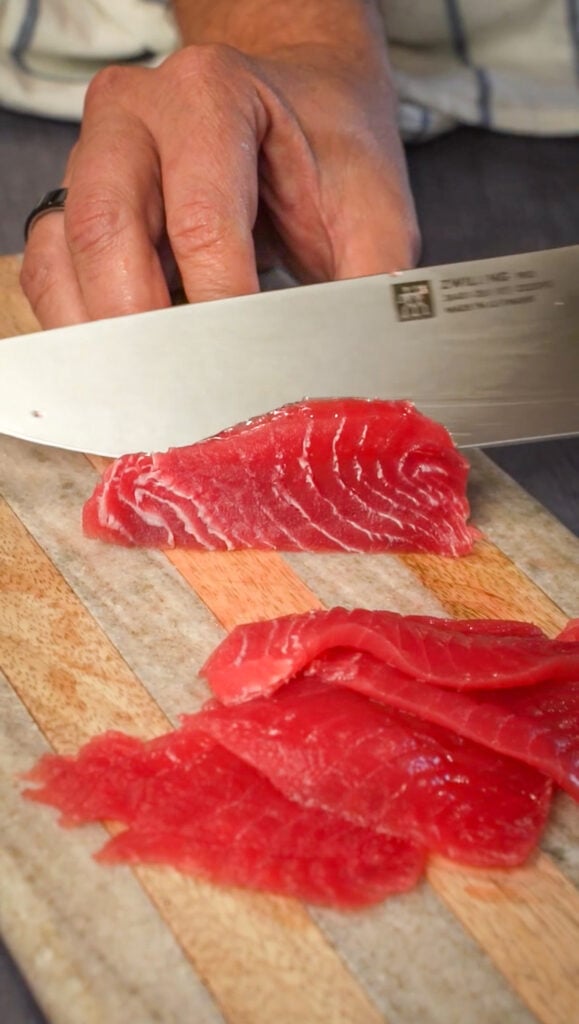 Slicing fish for a sicilian sashimi tuna carpaccio recipe.