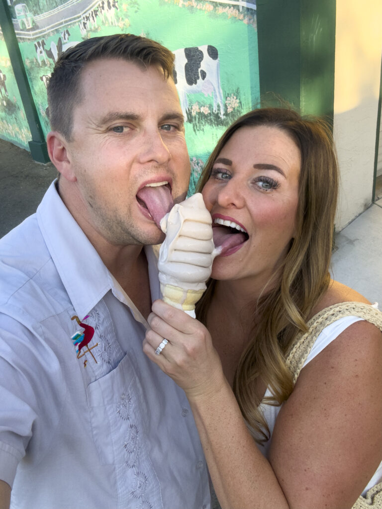 Couple licking an ice cream cone.