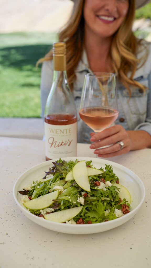 A glass of wine and a salad at a wine tasting one of the Top Things to Do in Livermore and Tri-Valley for Couples.