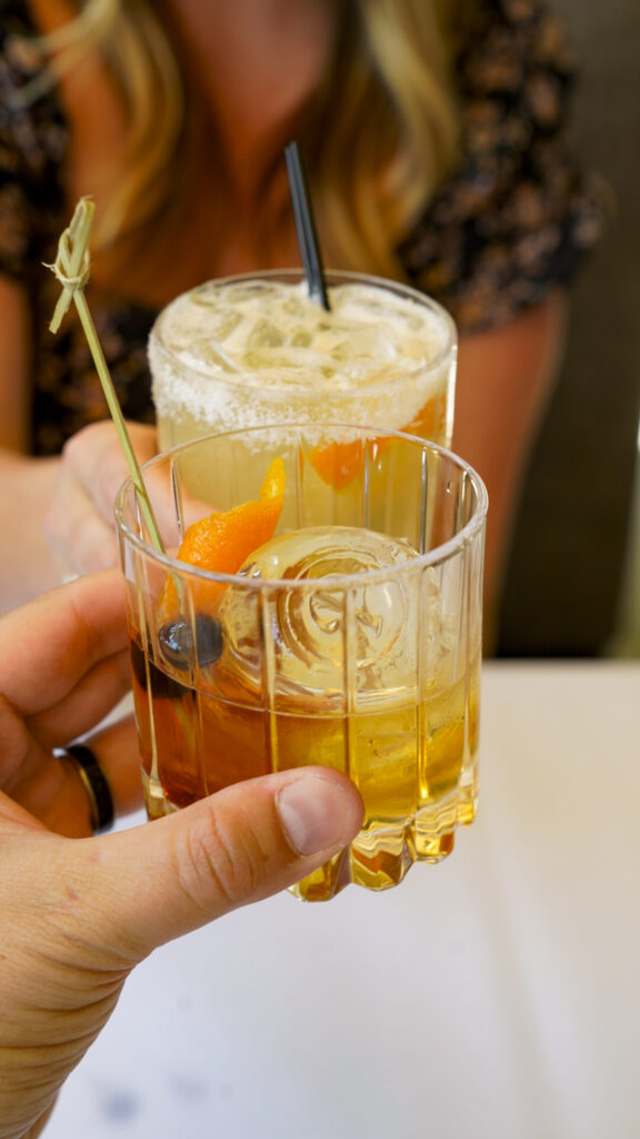 Couple toasting with drinks.