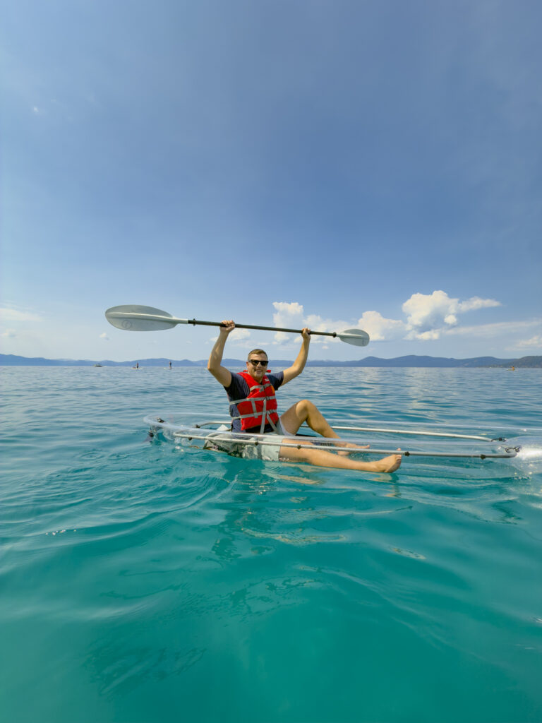 Man on a clear kayak with Clearly Tahoe in Lake Tahoe.