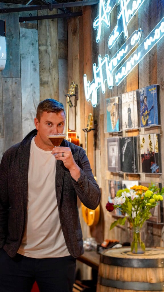 Man drinking a cocktail in a lounge inside of a Park City Utah speakeasy.