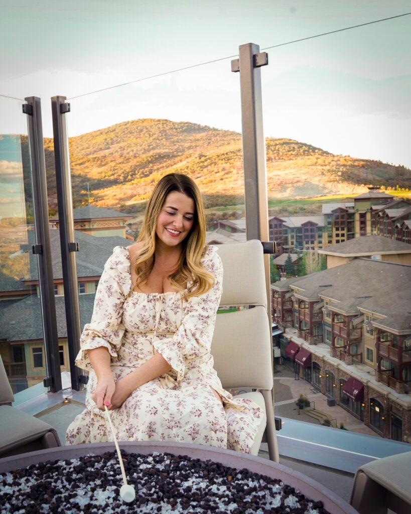 Woman roasting a marshmallow at the Pendry in Park City, Utah.