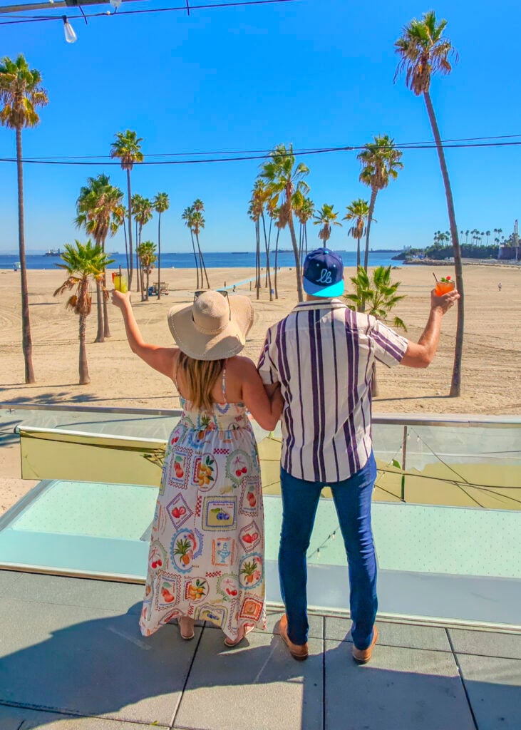 Couple with cocktails at Gaucho Beach rooftop in Long Beach, California.