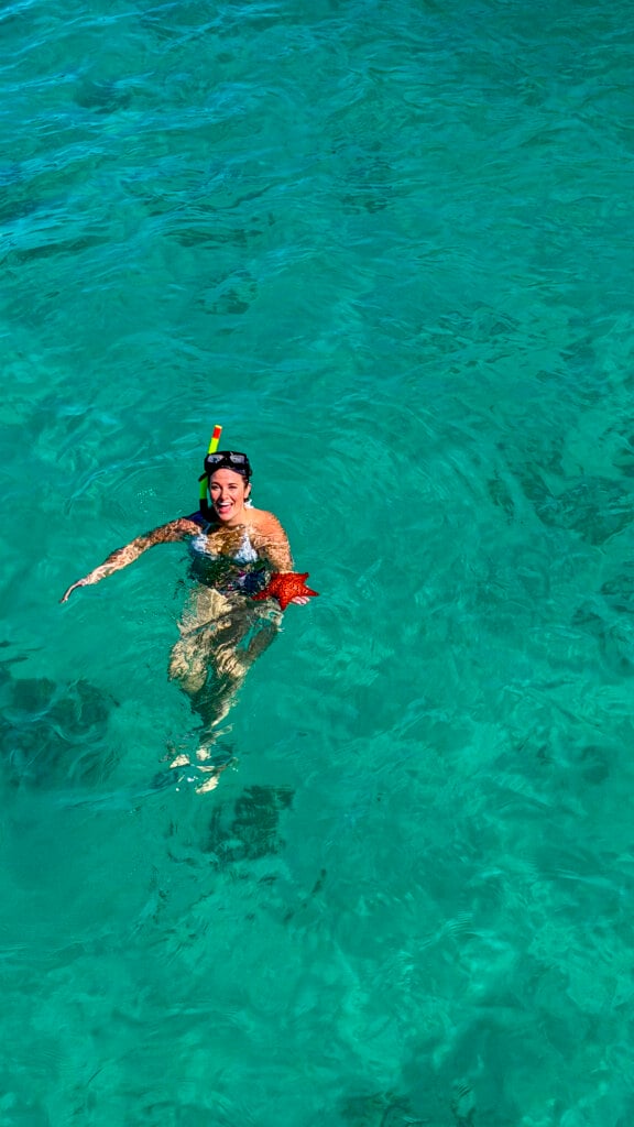 Woman with a starfish on a St. Martin private boat charter.