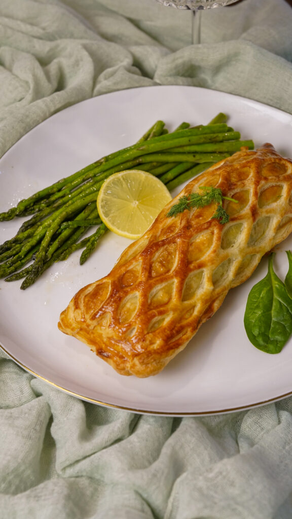 Salmon en Croute Salmon Wellington Recipe on a plate with asparagus.
