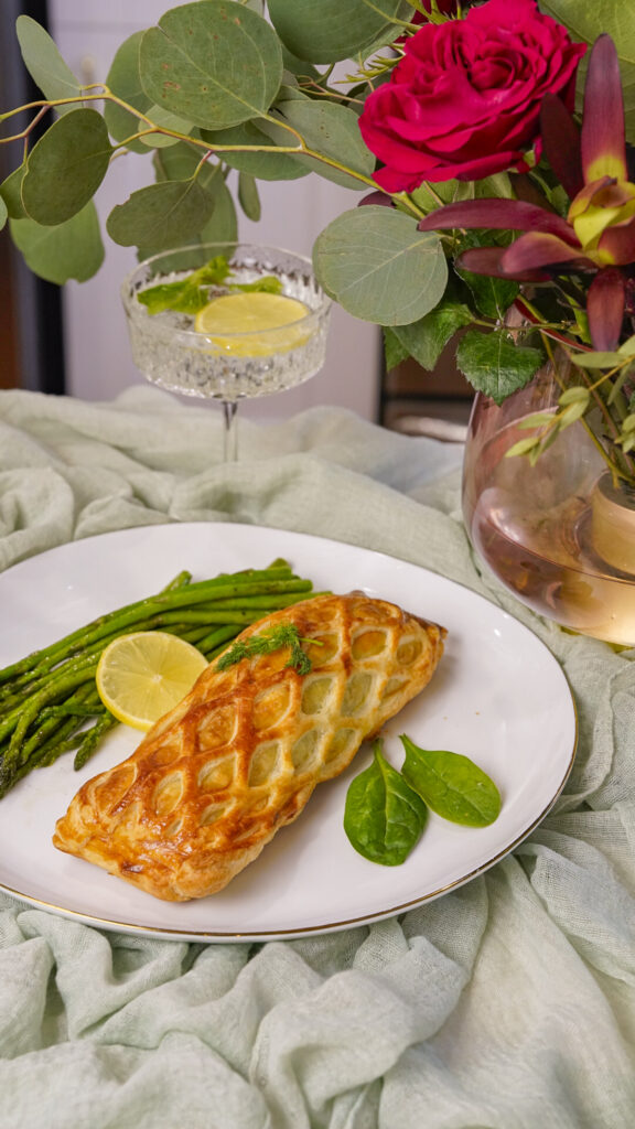 Salmon en Croute Salmon Wellington Recipe on a plate with asparagus.
