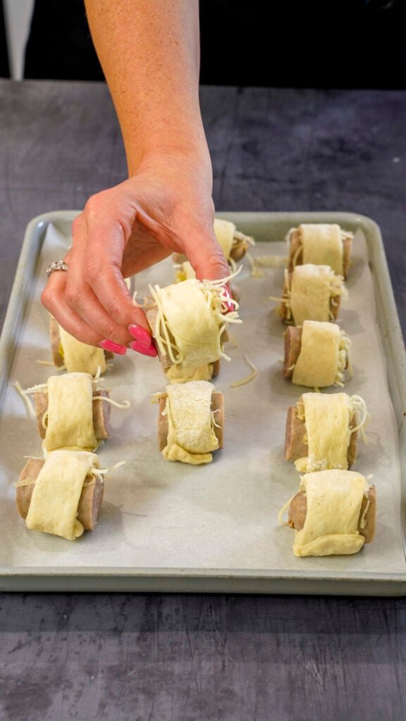 Brats in a blanket recipe on a baking sheet.