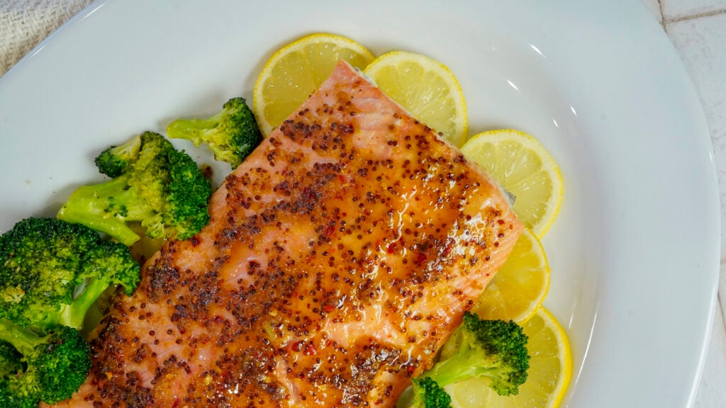 Honey mustard salmon recipe on a bed of lemon slices.