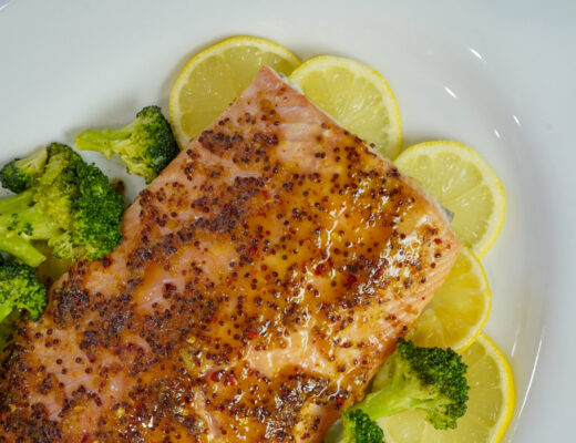 Honey mustard salmon recipe on a bed of lemon slices.