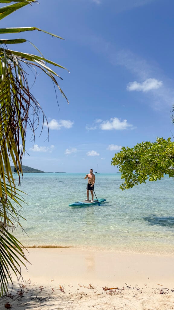 A man paddleboarding on a stop on the Windstar Tahiti French Polynesia cruise.