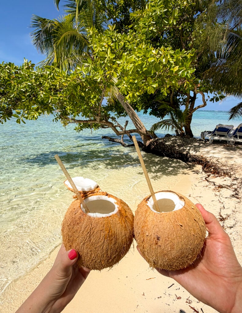 Couple with coconuts on a stop on the Windstar Tahiti French Polynesia cruise.