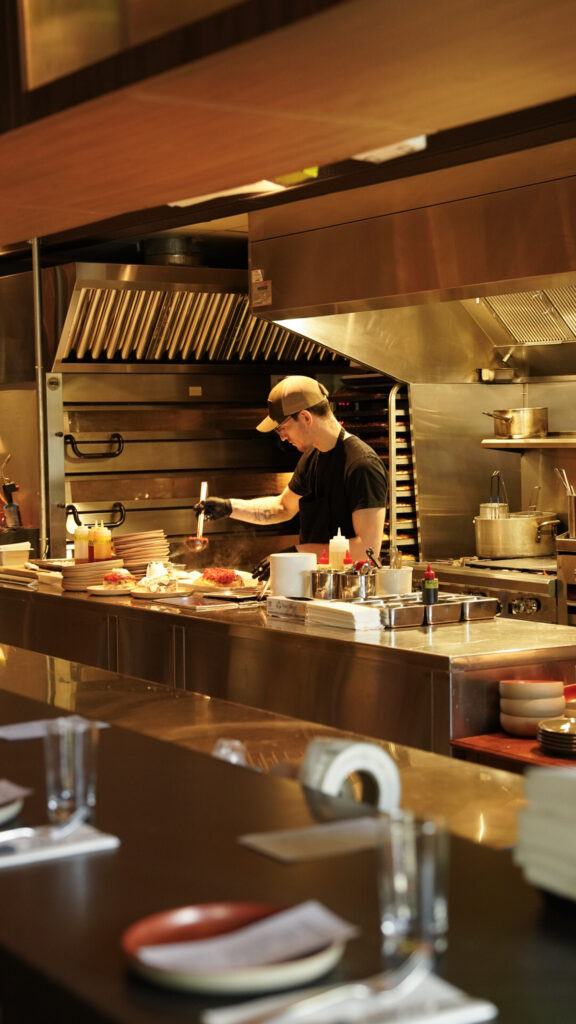 Chef cooking in an open kitchen as a Nashville Michelin Restaurant.