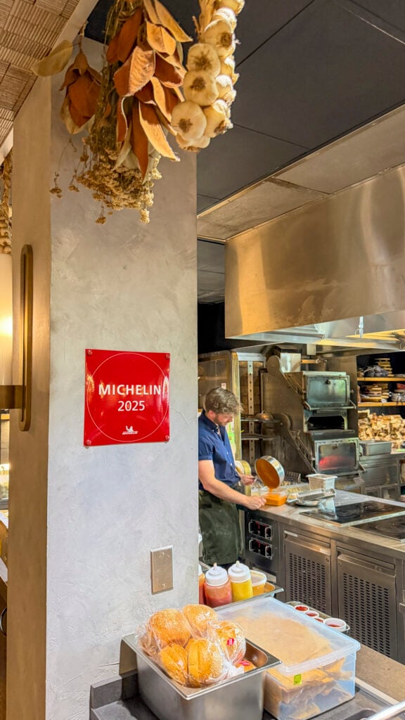 Chef next to a Michelin restaurant sign.