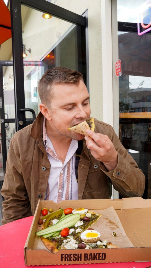Man eating a pizza in the San Francisco Peninsula.