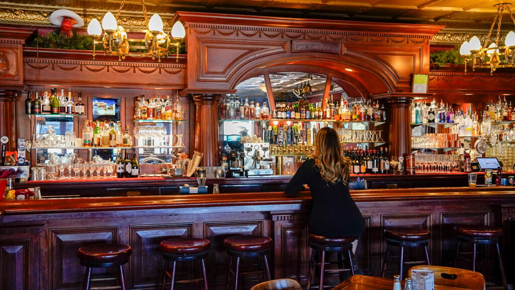 Woman sitting at the bar at The Pump House, one of the best restaurants in Fairbanks Alaska.